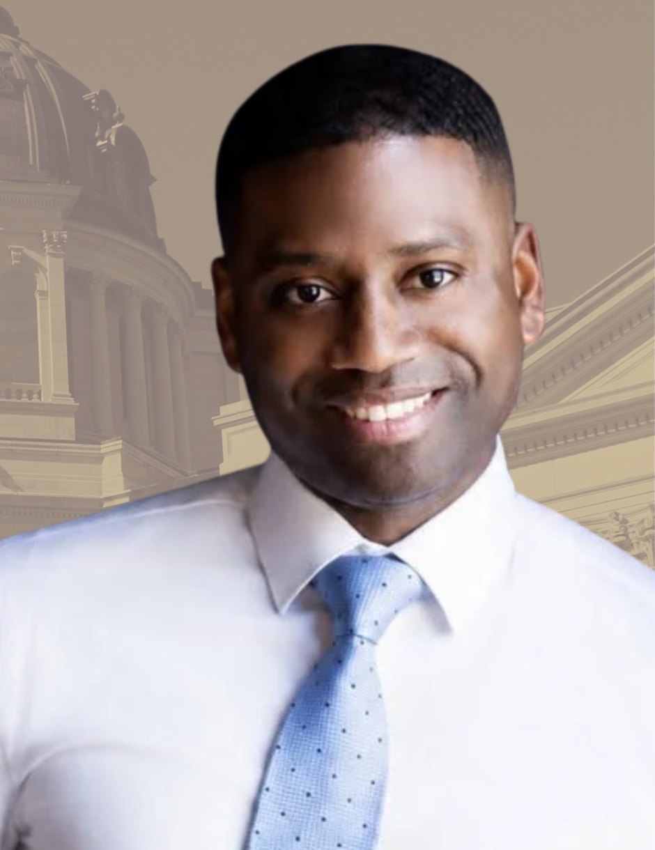 Terrence Davis in a white shirt and light blue tie, smiling, with the South Dakota State Capitol behind him