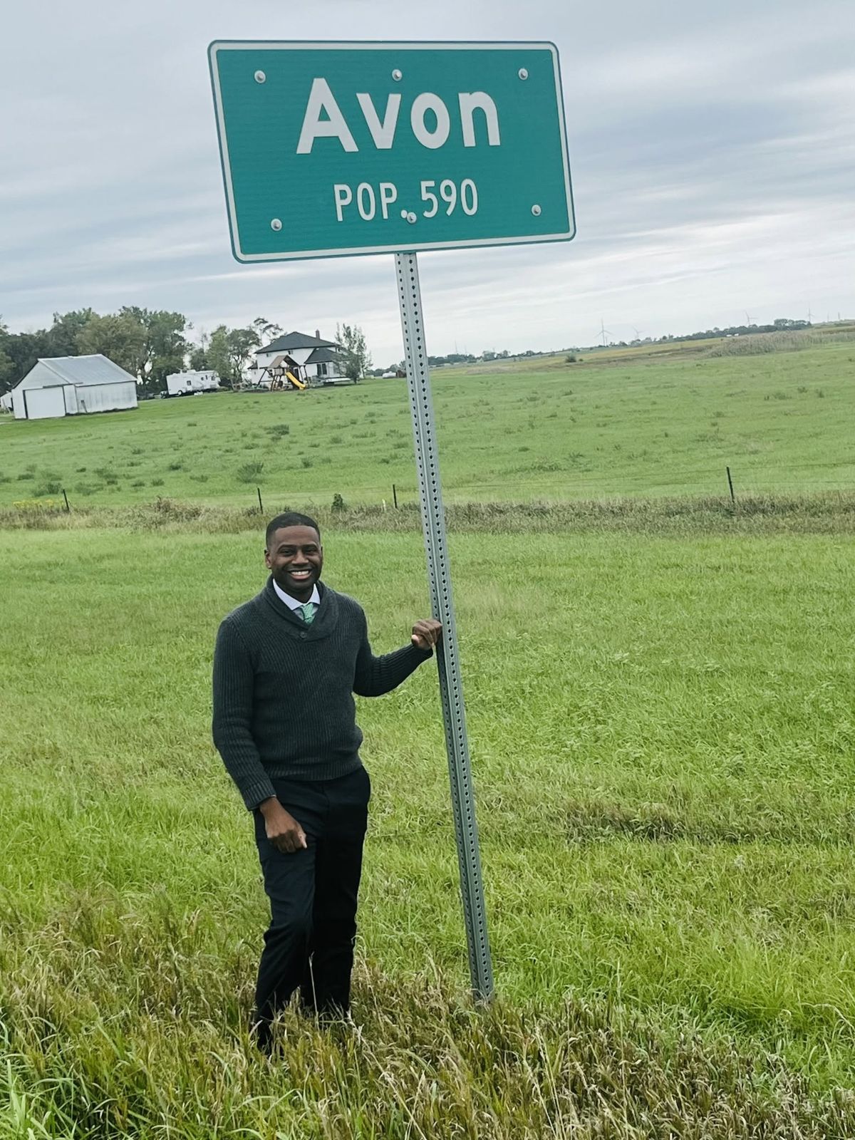 Terrence Davis standing by the Avon town sign in a green field